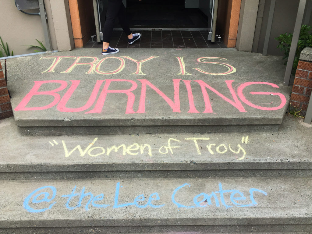 Chalk advertisements for Women of Troy cover the steps of the Fine Arts Building.