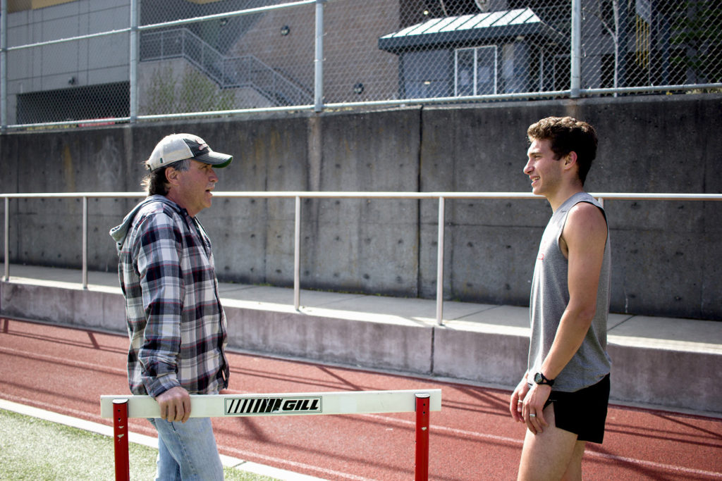 Seattle U Track and Field coach Kelly Sullivan talking to distance runner Eli Boudouris.