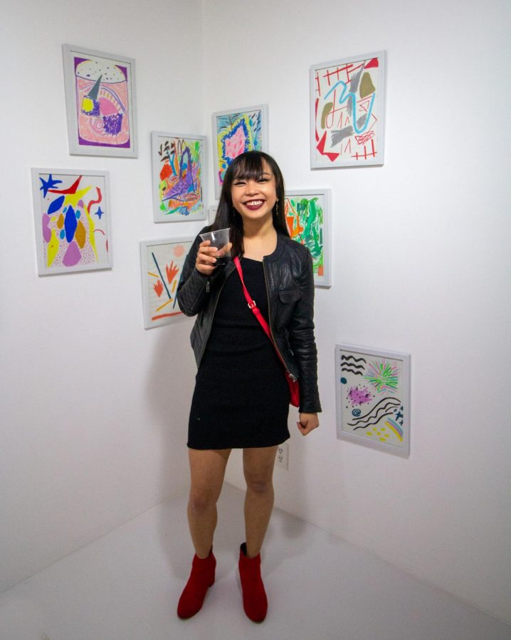 Artist Nikita Ares poses in front of her paintings in the “CHADA!” exhibit which is on display at the Glassbox Gallery until March 14, 2020.