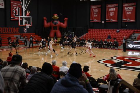 Seattle U womens basketball players passing the ball with a watchful crowd.