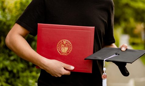 Seattle University diploma and cap held by 2021 alum. 