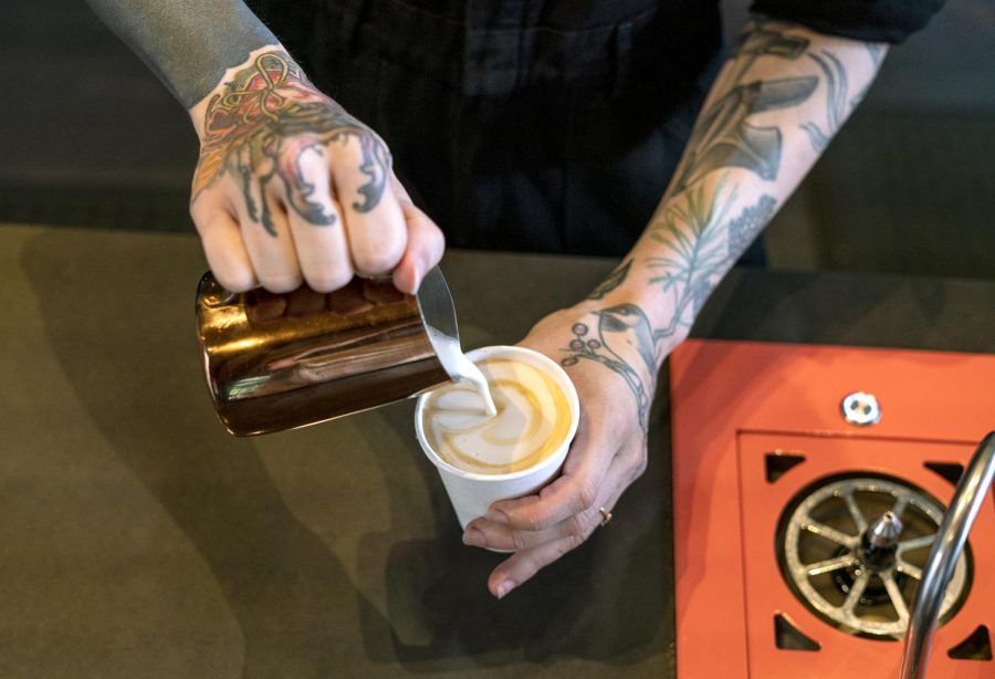 Barista making a pumpkin stuff latte at Anchorhead Coffee. 