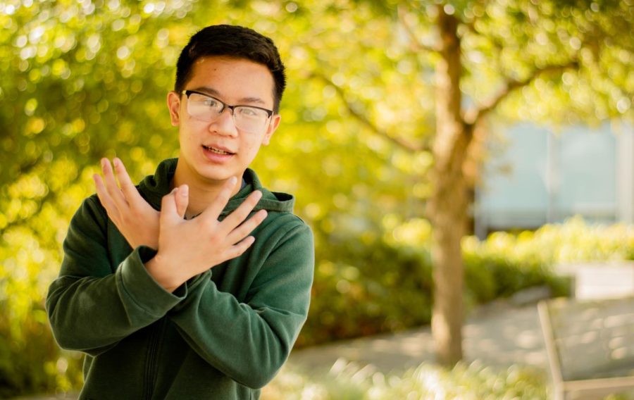 Max Tran, a computer science freshman holding up the Redhawk hand sign.