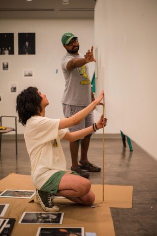 Nat Silva (Left) and Brian LaMar (Right), hang the display of Silva’s prints for the 2023 Bachelor of Fine Arts show at Seattle U. 