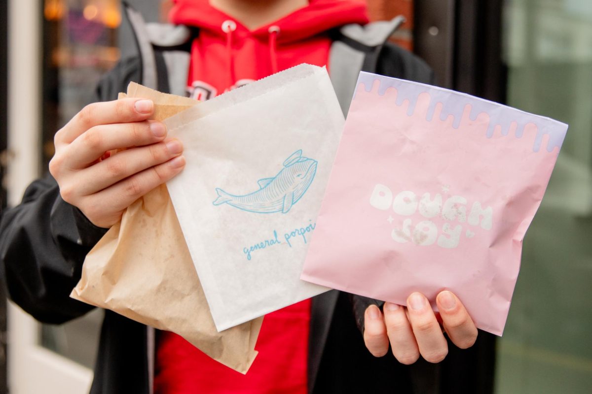 Spectator reporter, Kevin, holding up the donut bags from local Capitol Hill cafes: Mighty O’s, General Porpoise, and Dough Joy.