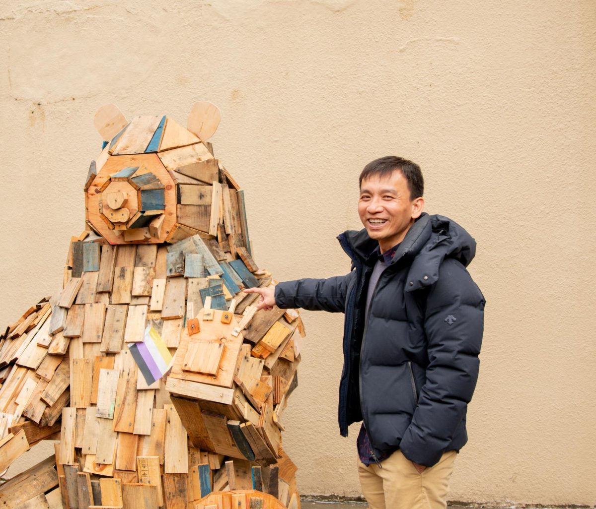 Trung Pham, Department Chair and Art professor, discussing the new wooden bear sculpture made by students.