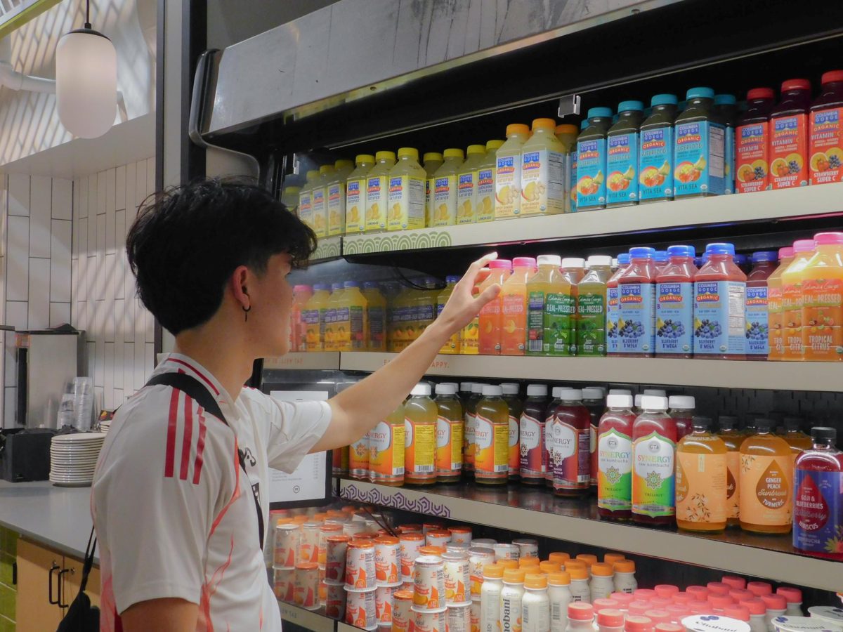 A student selects a drink from a Cherry Street Market fridge.