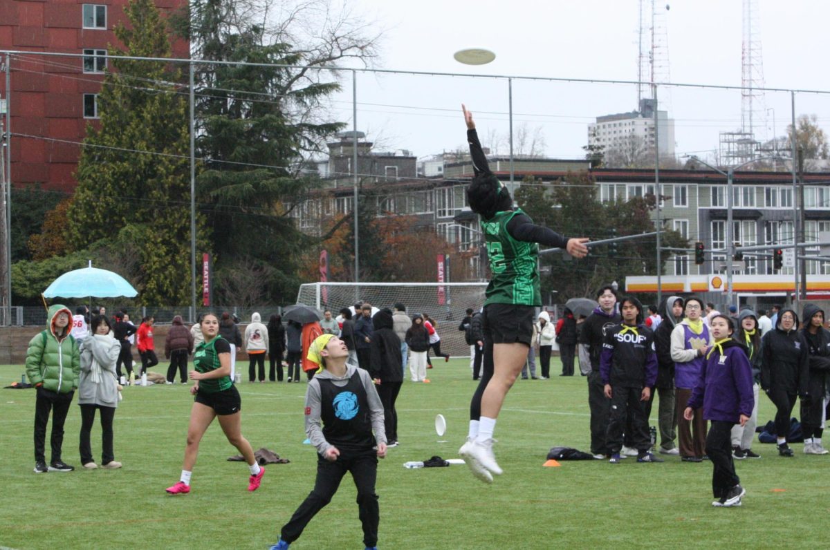 Player in a green jersey jumps for a pass.