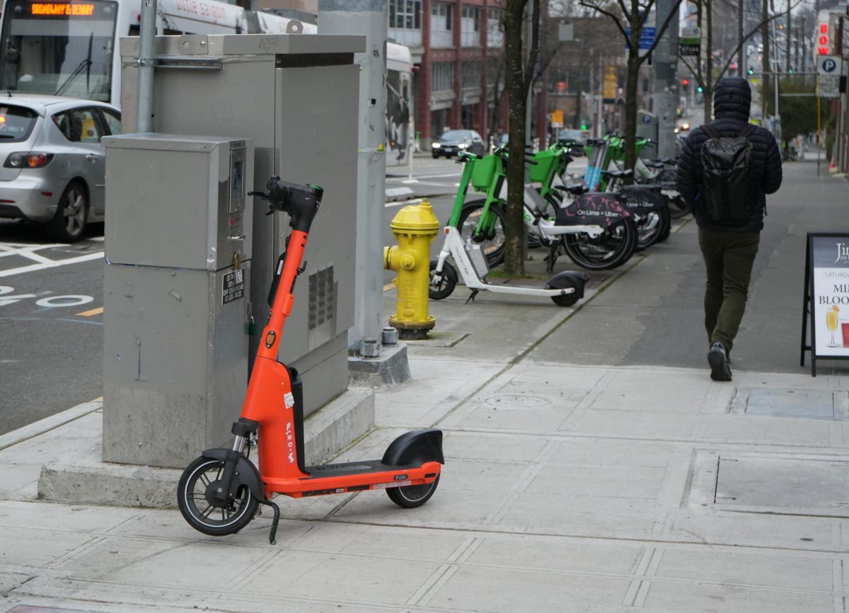 A man walks by a cluster of electric bikes and scooters on Broadway.