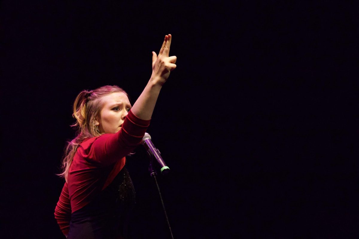 Lucy Johnson makes a gun-shaped hand gesture while performing a “If You Hadn’t But You Did,” a song about heartbreak.