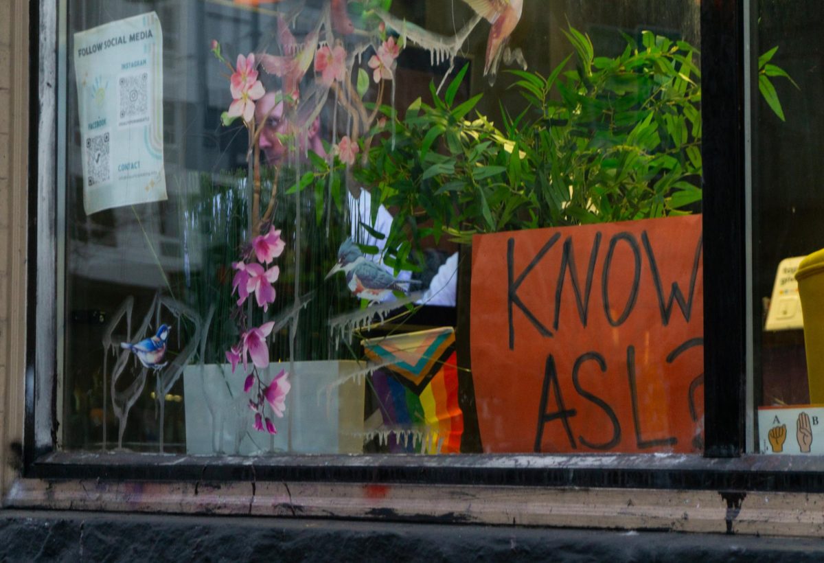 Through the window, vibrant decorations are visible alongside a sign asking, 'Know
ASL?'