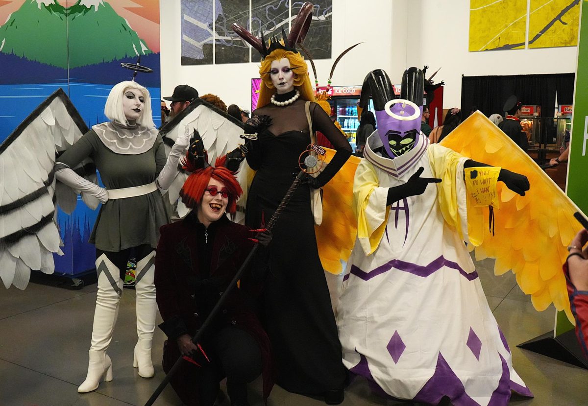 A group of Hazbin Hotel cosplayers pose for a photo.