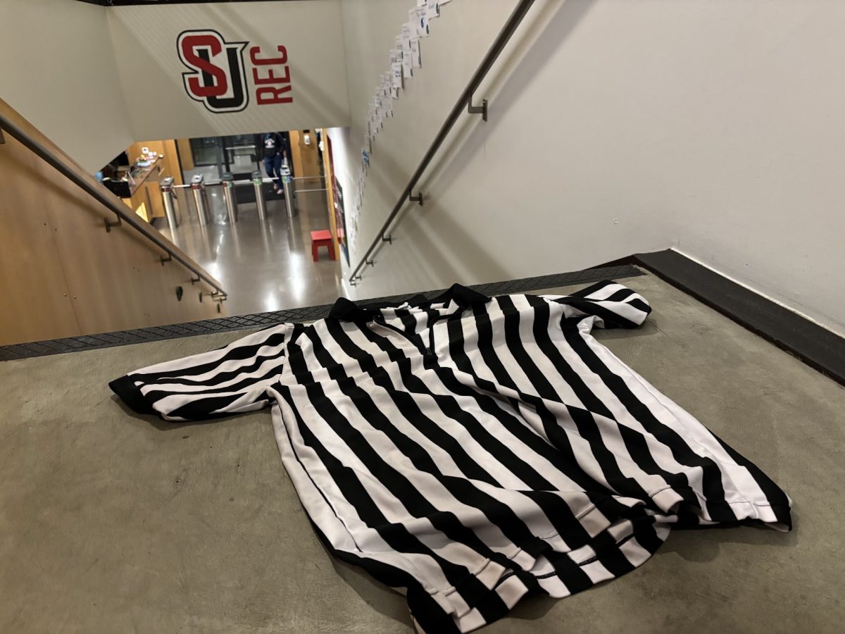 The unmistakable referee shirt worn by all UREC intramural officials sits in front of a UREC logo at the Eisiminger Fitness Center.