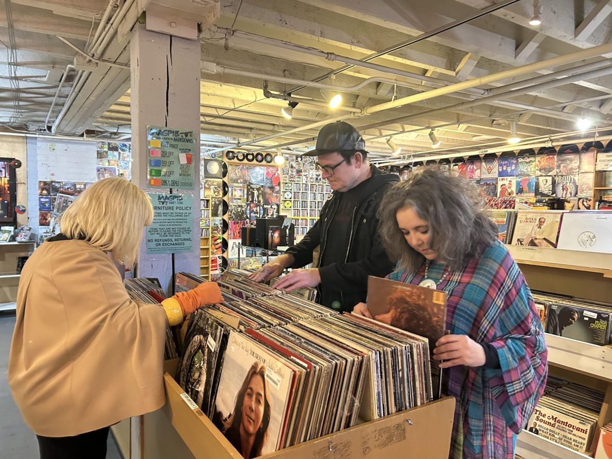 Customers browse through vinyl records on the lower level of Magpie Thrift.