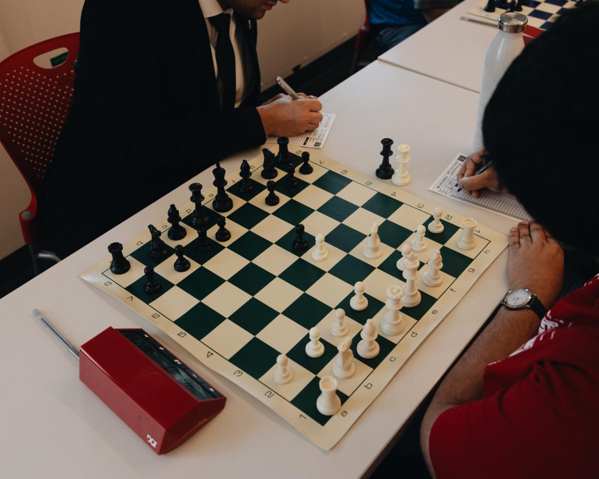 Two players notating their moves in the middle of their chess game