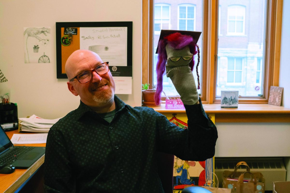 Professor Mark Cohan poses with his beloved puppet, Dr. Maggie Nificent.
