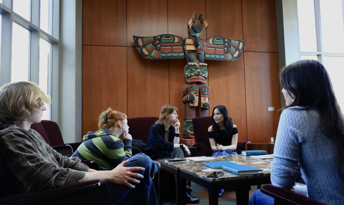 Fragments co-president Vanessa Vu (‘27) engages in a discussion with event coordinator Badger Compain (‘26), fellow co-president Sophie Flamoe (‘26), and interested students.