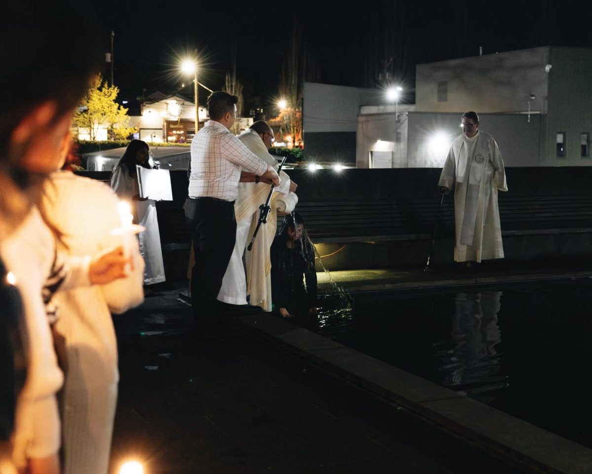 Thuli Shamsud-Din (‘29) gets baptized in the Reflecting Pool of the Chapel of St. Ignatius.